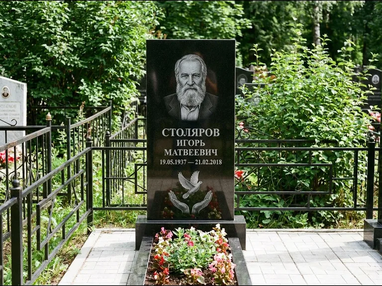 Памятник с гравировкой голубей — гравировка голубя над раскрытыми ладонями внизу стелы, работа «Столяров» в Сургуте