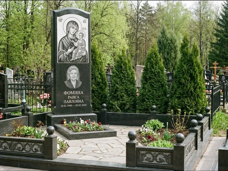 Памятник с гравировкой иконы: высокий гранёный обелиск с крестом-навершием — гравировка образа Матроны Московской, открытый участок без ограды, работа «Третьяков» в Сургуте