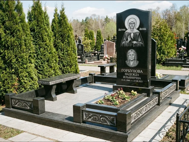 Памятник с гравировкой иконы: стела в форме раскрытой книги с образом — гравировка образа Спасителя, цоколь тёмной плиткой, работа «Зотов» в Сургуте