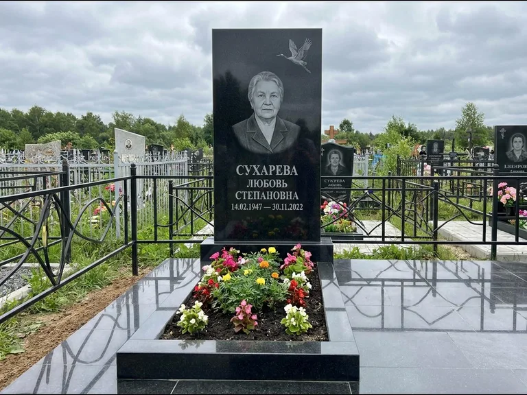 Памятник с гравировкой журавлей — гравировка одиночного летящего журавля над портретом, работа «Сухарева» в Сургуте