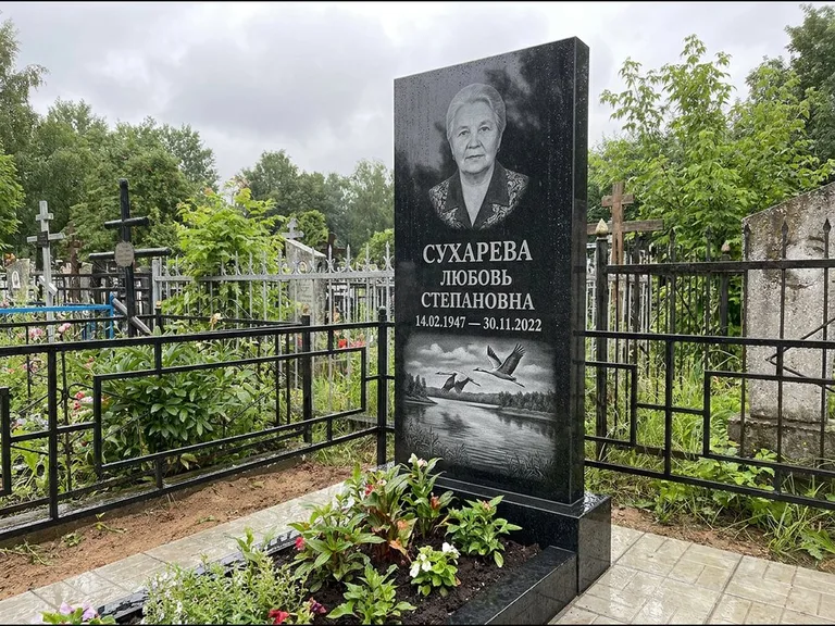 Памятник с гравировкой журавлей — гравировка пары журавлей над гладью озера в нижней части, работа «Сухарева» в Сургуте