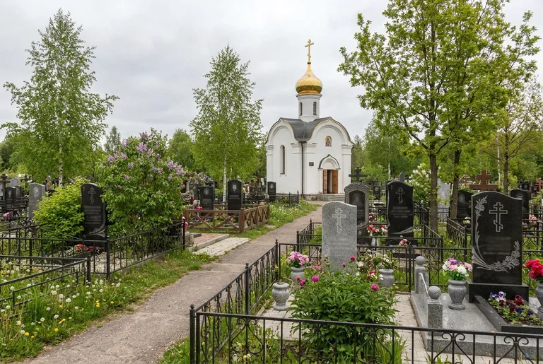 Мастер мастерской «Мастер Каменев» проверяет установку гранитной стелы на Кузьмоловском кладбище