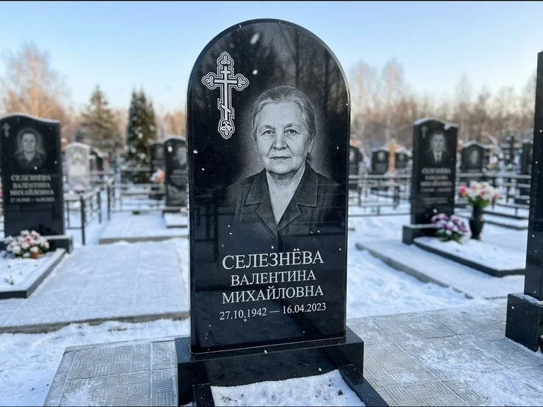 Памятник из чёрного гранита — массивная стела с крестом в лучах с крестом в лучах, работа «Одинцова» в Сургуте