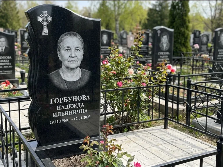 Памятник из чёрного гранита — высокий обелиск с кельтским крестом, работа «Одинцова» в Сургуте