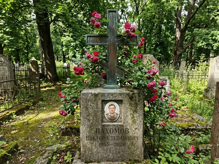 Бронзовый крест с розами на гранитной плите в Сургуте